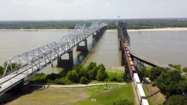 Yük treni, araba trafiği, Vicksburg Köprüsü ve Eski Vicksburg Köprüsü üzerinde hız yapan nehir teknesi, 20 numaralı karayolu köprüsü ve ABD 'nin Mississippi Nehri boyunca 80 numaralı karayolunu taşıyan ABD köprüsü.