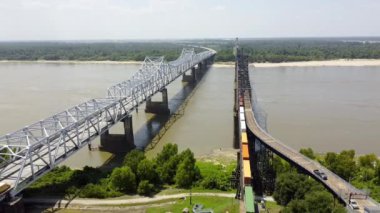 Yük treni, araba trafiği, Vicksburg Köprüsü ve Eski Vicksburg Köprüsü üzerinde hız yapan nehir teknesi, 20 numaralı karayolu köprüsü ve ABD 'nin Mississippi Nehri boyunca 80 numaralı karayolunu taşıyan ABD köprüsü.