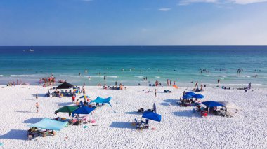 Renkli plaj şemsiyesi ve insanlar yüzüyor, şeker beyazı kumsallarda dinleniyor, mavi turkuaz su Destin, Güney Walton, Florida, ABD. Hava görünümü