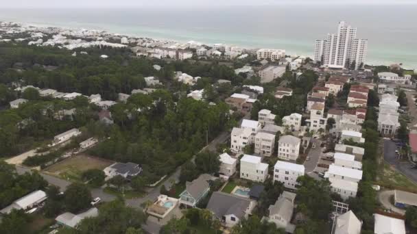 在美国佛罗里达州圣塔罗萨的30A县道 海湾海岸线和翡翠海岸的海滨社区 飞过公寓大楼 白色的三层度假别墅 绿树成荫 绿树成荫 — 图库视频影像