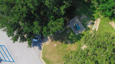 Güney meşe ağacı gölgelerinin altındaki dinlenme alanındaki Asyalı aile yaz tatili için Jackson County Dinlenme Bölgesi Batı Gautier, Mississippi, ABD 'de piknik masası, minivan ve yol gezilerinin tadını çıkarıyor. Hava görünümü