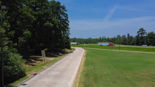 Entrance to rest area along highway interstate 10 (I-10) in Greenwood, Louisianan, USA surrounding by green pine trees, well-trimmed yards and picnic area. Aerial modern freeway stop, transportation