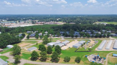 Depo, park alanı yakınlarındaki atölye binaları ve arka planda Richland, Mississippi şehir merkezindeki yeni yerleşim evleri. Jackson 'ın Aerial banliyösü, Rankin County, ABD