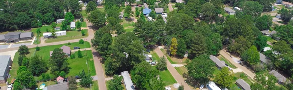 Panorama low density housing of mobile manufactured homes surrounding by lush green trees near Richland Westside Park, suburb Jackson, Mississippi, US large lot size. Aerial view trailer neighborhood