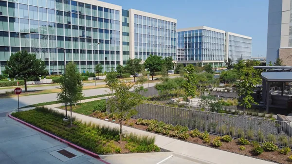 stock image Group of glass office building with nice landscaping and outdoor recreation yard in business center downtown Plano, Texas, USA. Aerial view modern corporate towers in Dallas Fort Worth metro complex