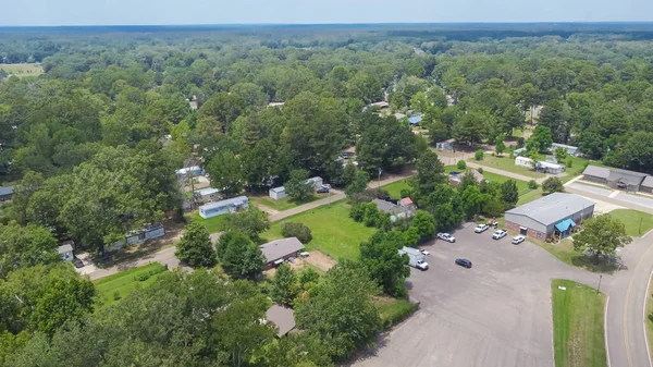 stock image Row of manufactured, modular, and mobile homes surrounding by lush green trees in Richland, Rankin County, Mississippi suburb of Jackson, USA established neighborhood. Aerial view affordable housing