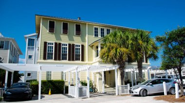 Santa Rosa, South Walton, Destin, Florida Panhandle 'da manzaralı 30A köy yolu boyunca beyaz pergola ve çit kaldırımlı üç katlı evler. Yerleşim evleri açık mavi gökyüzü