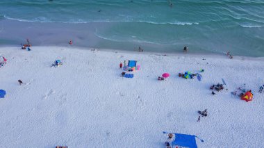Renkli çadırlar, plaj şezlongları, yüzen, dinlenen, turkuaz suyla beyaz kumlu sahil şeridi boyunca yürüyen, Güney Walton plajı, Destin, Florida 'da kalabalık insanlar. Seyahat hedefi