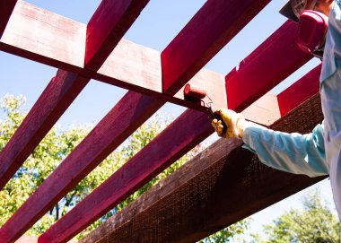 Kepli, maskeli, camlı, 4 inç paten boyalı pergola kereste kullanan, lateks su bazlı dış leke rengi, ev dekorasyonu, ev yenileme projesi olan işçiler. Becerikli