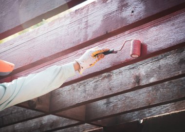 Asyalı erkek eli, 4 inç paten boyalı pergola kereste kullanarak eldivenler giyiyor. Sekoya lateks su bazlı dış leke rengi, ev dekorasyonu, ev yenileme projesi. Becerikli