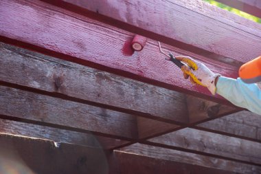 Asyalı adam kep, maske, nitrile kaplı eldivenler takıyor kaykaylı kızılağaç pergola ahşap ahşap bahçe bahçesi, Dallas, Teksas, ABD 'de uzun kollu gömlek, ev yapımı. DYI projesi