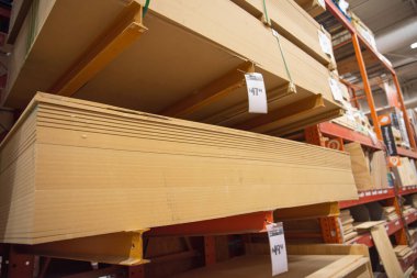Dallas, Teksas, ABD 'deki nalbur mağazasında üzerinde fiyat etiketleri bulunan MDF Orta Yoğunluklu Fiberboard panelleri, kontrplak uygulamasına benzer bir yapı malzemesi üretiyor. Sanayi geçmişi