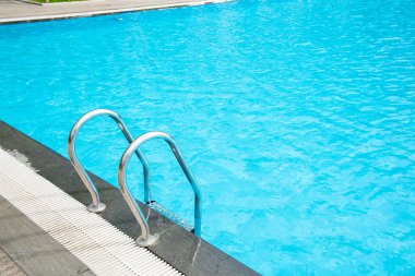 Bulanık ailenin yüzdüğü paslanmaz çelik parmaklıkların seçici odak noktası ve lüks otel palmiyeleri Nha Trang, Vietnam 'da arka planda dev flamingolarla oynamak. Seyahat