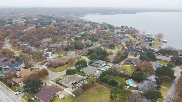 Aerial view residential homes with swimming pool, large backyard, matured trees next to Lake Arlington in Tarrant County, DallasFort Worth metroplex, upscale two story subdivision houses park. USA