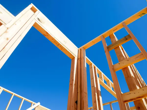 Dallas, Teksas 'ta, orta büyüklükteki tek bir aile evinin yeni temelinde kapı ve pencereler için kaba açıkları olan ahşap dış ve iç duvarlar, açık mavi gökyüzü. ABD