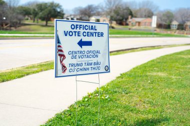 İngilizce, İspanyolca, Vietnamca dillerinde kazık saplanmış resmi Oy Merkezi tabelası ikamet eden ve İngilizce bilmeyen grupları Dallas, Teksas 'taki ilkokulda oy kullanırken karşılamak için. ABD