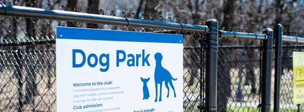 Panorama dog park sign with rules policies on galvanized vinyl-coated chain link fences, steel posts panels at rest area public picnic location along highway in Oklahoma, security fencing gate. USA