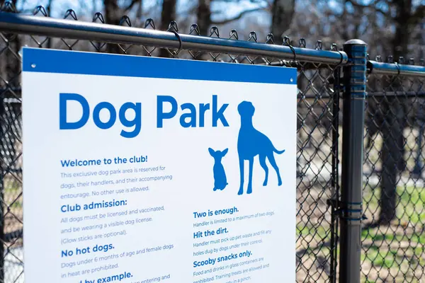 Dog park sign with rules policies on galvanized vinyl-coated chain link fences, steel posts and panels at rest area public picnic location along highway in Oklahoma, security dog fencing gates. USA