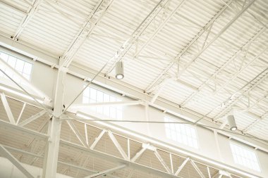 Geniş bir depo tarzı bina. Geniş pencereleri var. Modern çatı kirişleri, LED ışıklar, asma tavanlı metal çatı yapısı, çelik depo fabrikası, Texas. ABD