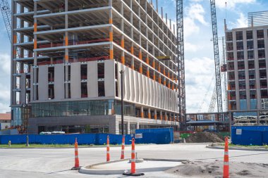 Koni bahçeli inşaat alanı, yüksek katlı oteller, ofis binası, gökdelen yapısı, çalışan vinçler, Irving, Teksas şehir merkezinde alt kattaki beton duvar, ticari gayrimenkul. ABD