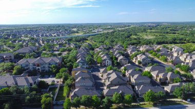 Brushy Creek Yolu 'nun çevresindeki yemyeşil ağaçlarla çevrili iki katlı, tek kişilik aile evleri ve E Whitestone Bulvarı arka planı Cedar Park, Austin, Texas, havacılık. ABD