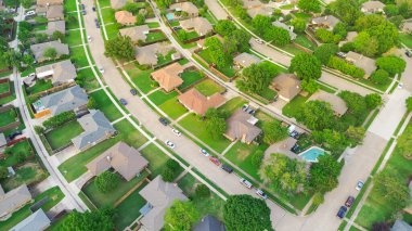 Dallas, Teksas 'ın alt kesimindeki banliyö evlerinin ön bahçesinde park halindeki arabaları olan yerleşim yerleri. Havadan kopmuş tek aile evleri büyük arka bahçeli çitler. ABD