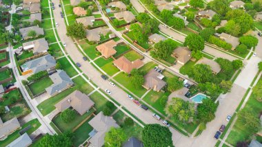 Residential streets with parked cars along row of suburban houses well-trimmed front yard landscape in subdivision suburbs Dallas, Texas, aerial detached single family homes large backyard fence. USA clipart
