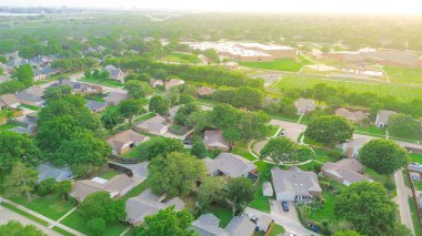 Uçan manzaralı banliyö mahallesi çıkmaz sokak, yemyeşil ağaçlar, ortaokul kompleks futbol sahası, oyun alanı, Kuzey Teksas, Dallas. ABD