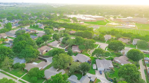 stock image Aerial view suburban residential neighborhood with cul-de-sac dead-end keyhole street, lush greenery trees, middle elementary school complex football track field, playground, North Texas, Dallas. USA