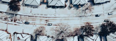 Panorama view row of single-family houses covered in heavy snow on shingles roofing, residential street suburban Dallas-Fort Worth metropolitan, severe weather, climate change, sunshine melting. USA clipart