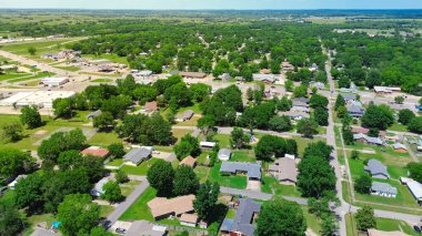 Aerial view suburbs of Checotah, McIntosh County, Oklahoma toward north of interstate I-40, east of Highway 69, suburban single-family houses on large lot size lush trees along 4th street, sunny. USA clipart