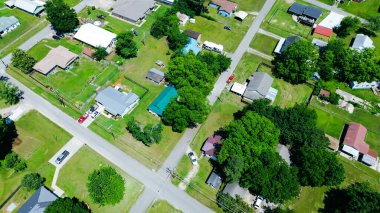 Arka bahçesi geniş banliyö evleri, Checotah, McIntosh County, Oklahoma 'da depolama kulübeleri, uzun olgun ağaçlarla çevrili orta gelirli tek aile evleri, oldukça caddeler. ABD