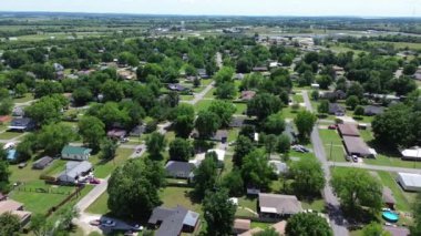 Checotah, McIntosh County, Oklahoma 'da sakin bir yerleşim yeri. Bir sıra tek aile evi. Arka planda su kulesi, güneşli günler üstgeçidi olan I-40 eyaletine doğru geniş bir arka bahçe.