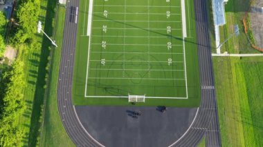 Üst geçitteki futbol sahalarında 10 yard 'lık saha artışları, koşu pistleri, futbol golleri, çim biçme antrenmanları, Dallas Fort Worth Metro kompleksi varoşları