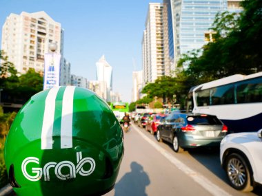 22 DEC, 2023-HANOI: Yoğun otobüs, araba ve motosiklet trafiği, Kap Kap sürücüsü kaskı, Grab Güneydoğu Asya 'nın önde gelen süper uygulaması, Singapur merkezli şirket