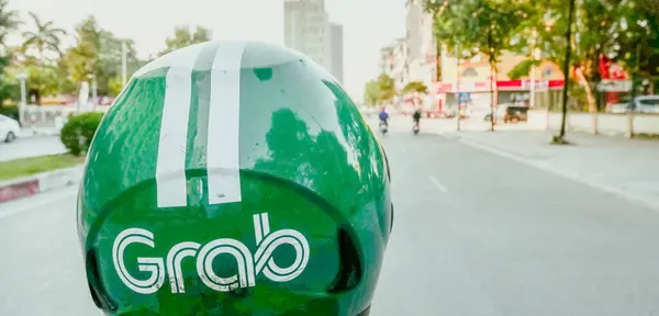 Stock image DEC 22, 2023-HANOI, VN: Panorama view Ha Noi street early morning with close-up POV helmet of Grab ride sharing driver using motorbike, Grab is Southeast Asia leading superapp, Singapore-based company