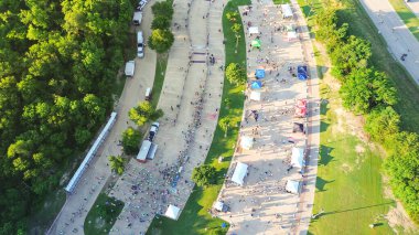 Renkli çerçeve çadırları ve taşınabilir tuvaletler yerel park, Plano, Texas 'taki yarış etkinliklerinde koşucuların kalabalık olduğu açık hava sporu katılımcılarından önce havadan bekleme. ABD