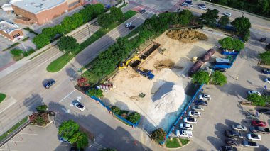 Coppell, Texas 'ta banliyö marketinin köşesindeki işlek cadde kesişme istasyonu inşaatı kepçeli süpürge kazıcısı, çöp kamyonu, buldozer kazısı büyük tankları ve antenleri gömmek için. ABD