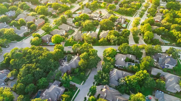 stock image Upscale neighborhood large residential houses with swimming pools surrounding lush green trees North of Dallas Fort Worth metroplex, expensive suburban mansion homes, large backyard, aerial view. USA