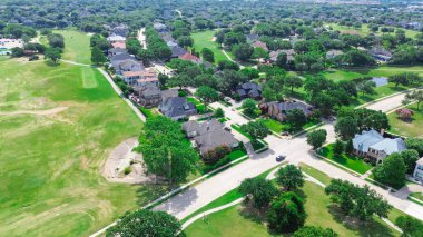Varoş parkında geniş çimenli bir alan var. İki katlı konak, yüzme havuzu, golf sahası çevresi North Plano, Dallas Fort Worth Metroplex, hava manzaralı. ABD