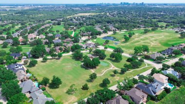 Lüks yerleşim yerlerinde şehir içi yeşillik alan, arka planda Plano Texas şehir merkezi, golf sahası topluluğu, iki katlı malikane evleri yüzme havuzu, Dallas, hava manzarası. ABD