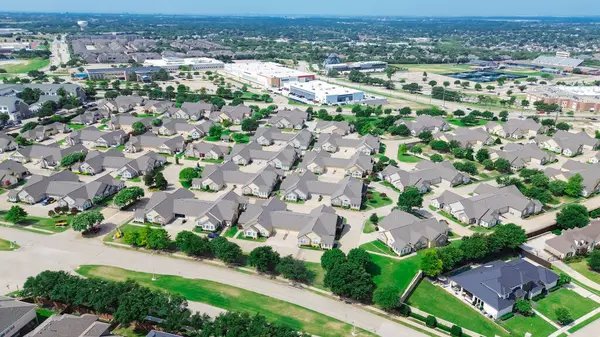 stock image Aerial view premier active adult communities and nursery homes, commercial building warehouse, city water tower in background, upscale West Plano, Texas, condominium duplex with maintenance-free. USA