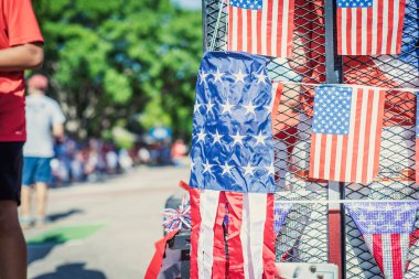 Windsocks American flag and dense string of flags on July Fourth parade, blurry diverse participants, Red White Blue Streamers fringe curtain on steel mesh utility trailer truck, Independence Day. USA clipart