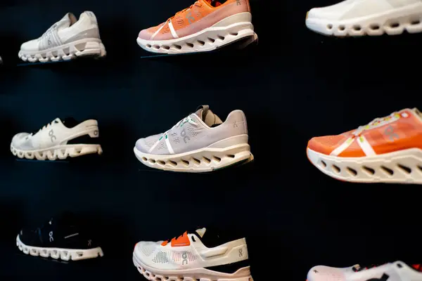 Stock image SOUTHLAKE, TX, US-JUNE 12, 2024: Rear view selection of On road running racing shoes on wall shelf display at upscale sport shop, On Holding AG is an Switzerland athletic shoe, performance sportswear