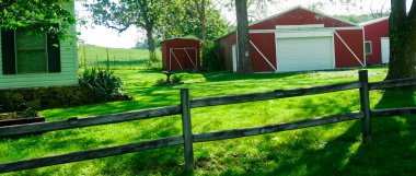 Mansfield Missouri 'de uzun tahta at ya da çitle çevrili Panorama manzaralı tipik ahır tarzı çiftlik evi, yemyeşil ağaçlar, tarım kasabasının kırsal kesiminde manzaralı tarım kasabası. ABD