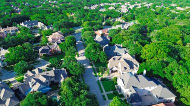 Coppell, Texas 'taki lüks banliyö semtindeki büyük malikaneleri çevreleyen yeşillik yemyeşil orman alanı Dallas Fort Worth Metroplex banliyösü ve hava manzaralı pahalı evleri. ABD