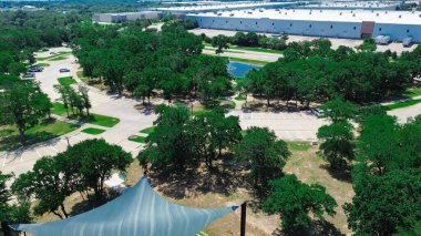 Endüstriyel bölgenin yakınındaki yemyeşil banliyö parkında büyük bir depo, lojistik depo, Flower Mound 'daki nakliye konteynırları, Dallas Fort Worth Metroplex' in banliyöleri, anten. ABD
