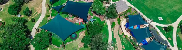 stock image Panorama aerial view children recreation center with splash pad, shade sail covered playground and diverse kids playing at suburban park in Flower Mound, Texas, community activity hot summer day. USA