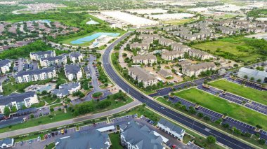 Kıvrımlı cadde, yüzme havuzlu yeni apartman kompleksi, karışık kullanımlı ana yerleşim yerlerinde metal çatı, tek aile evleri, depo sanayi bölgesi, hava sahası. ABD