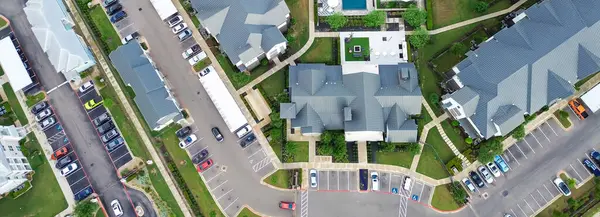 stock image Panorama aerial view entrance to new apartment complex with leasing office and metal roofing buildings, farmhouses style rental community in Pflugerville, fast-growing city suburbs of Austin. USA